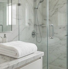Baño de mármol con toallas blancas